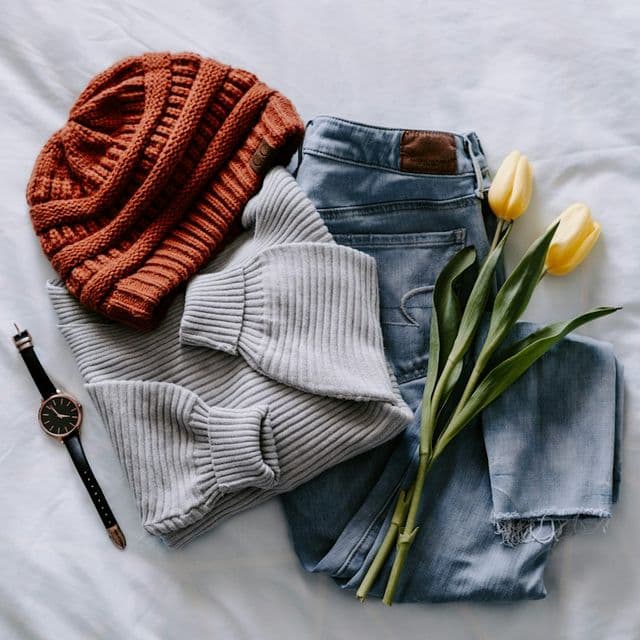 Pull, jean et bonnet pliés à plat avec une montre